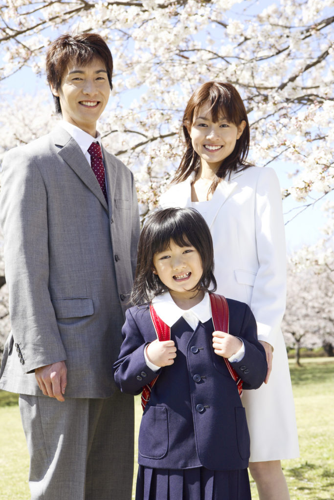 A girl and her parents are in front of Cherry tree