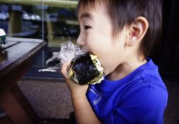 a child eats a big ONIGIRI rice ball