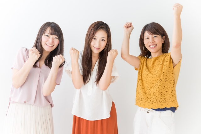ガッツポーズで喜びを表現する三人の女性の写真