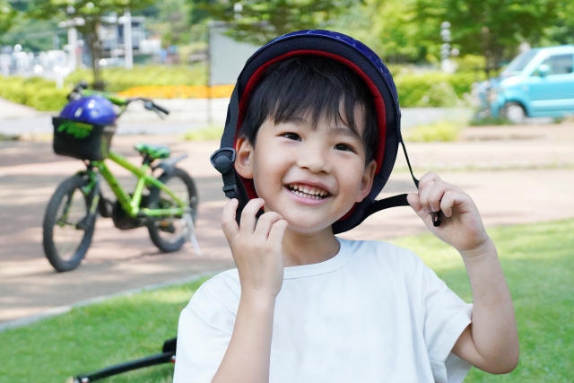 自転車ヘルメットをかぶる子どもの写真