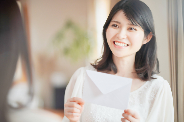 手紙を手に微笑む女性